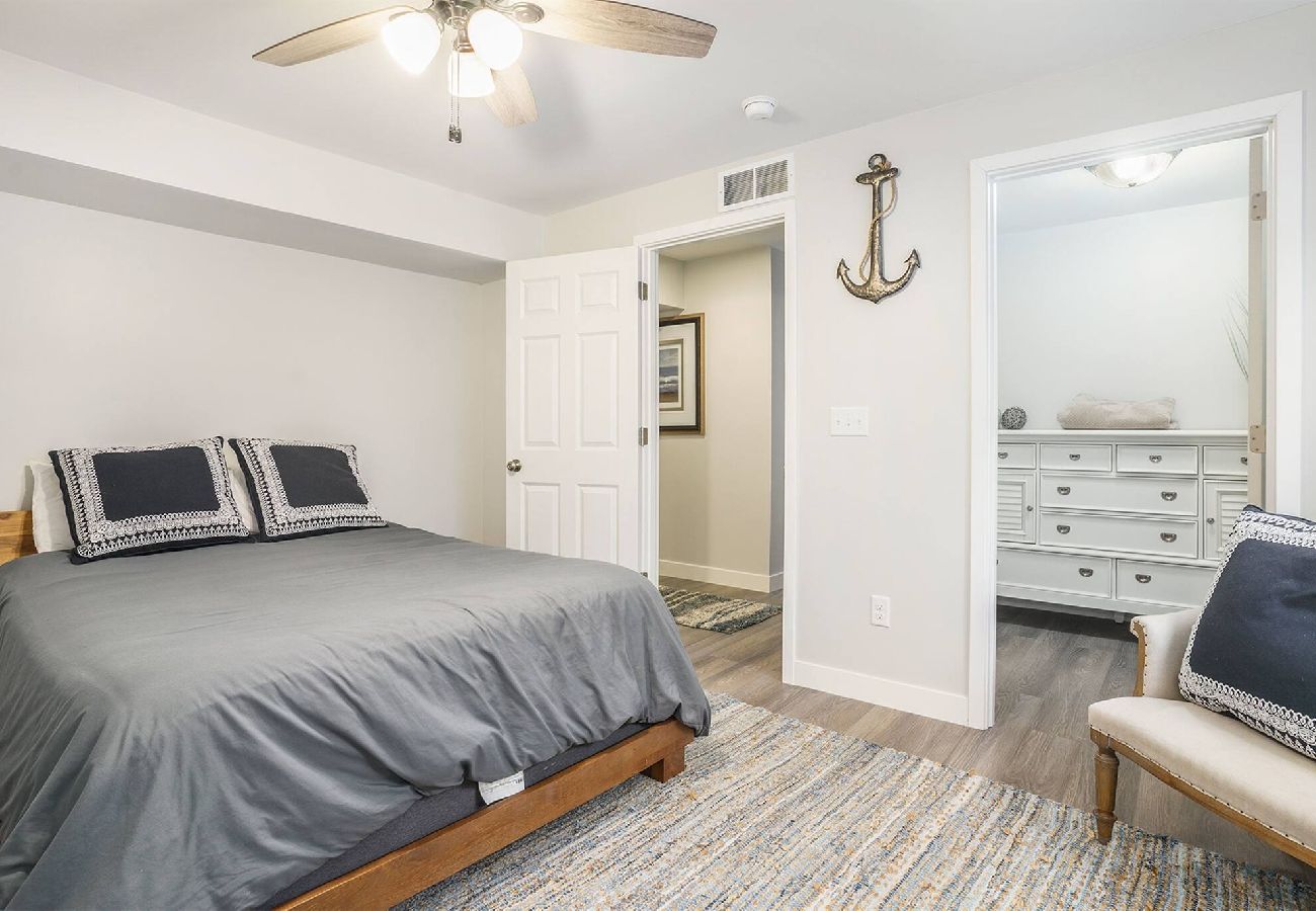 Bedroom with king bed, nautical decor, and dresser at Bridgewater Cottage