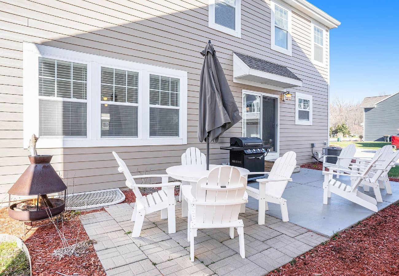 Back patio at Bridgewater Cottage featuring Adirondack chairs and gas grill.