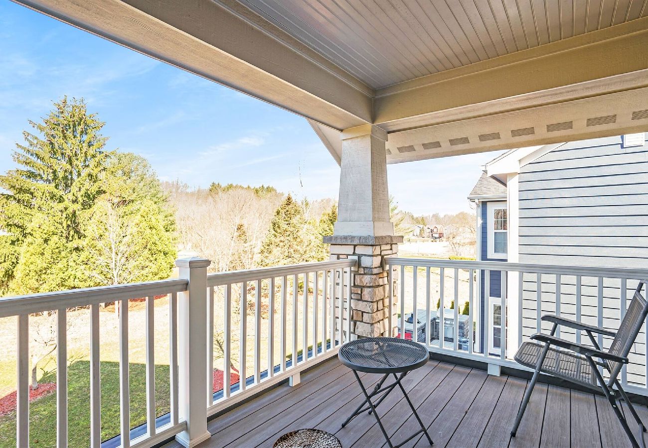 Private en-suite balcony with covered roof, white railings, and outdoor seating