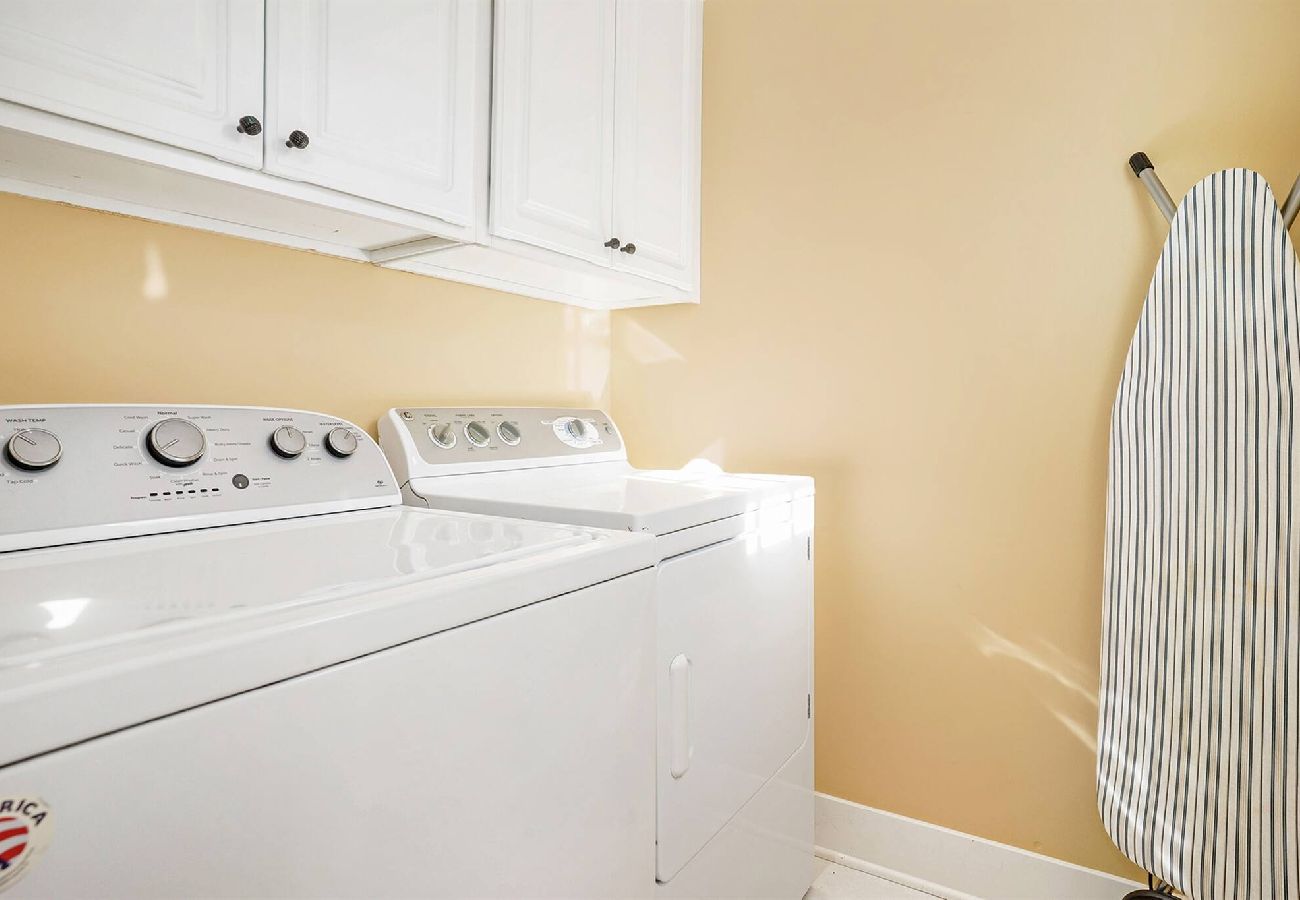 Laundry room with full-size washer and dryer and ironing board