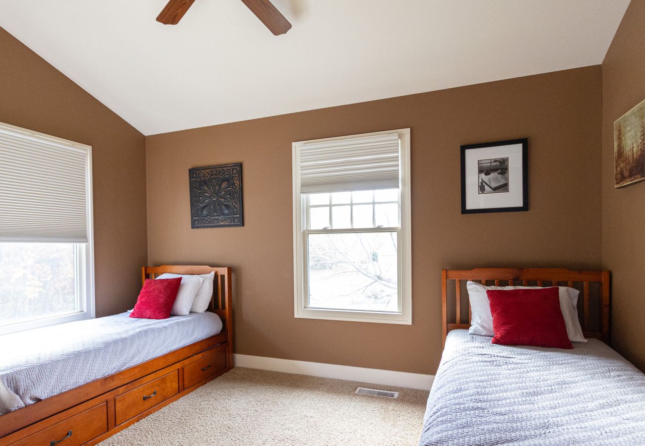 Bedroom with two twin trundle beds and neutral walls at Daydreamer Cottage 
