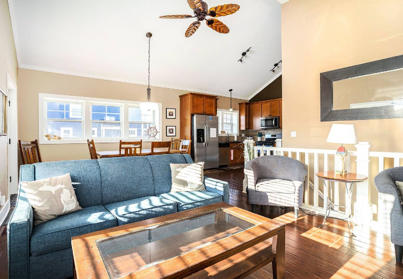 Bright open-concept living room, dining area, and fully equipped kitchen with cozy seating