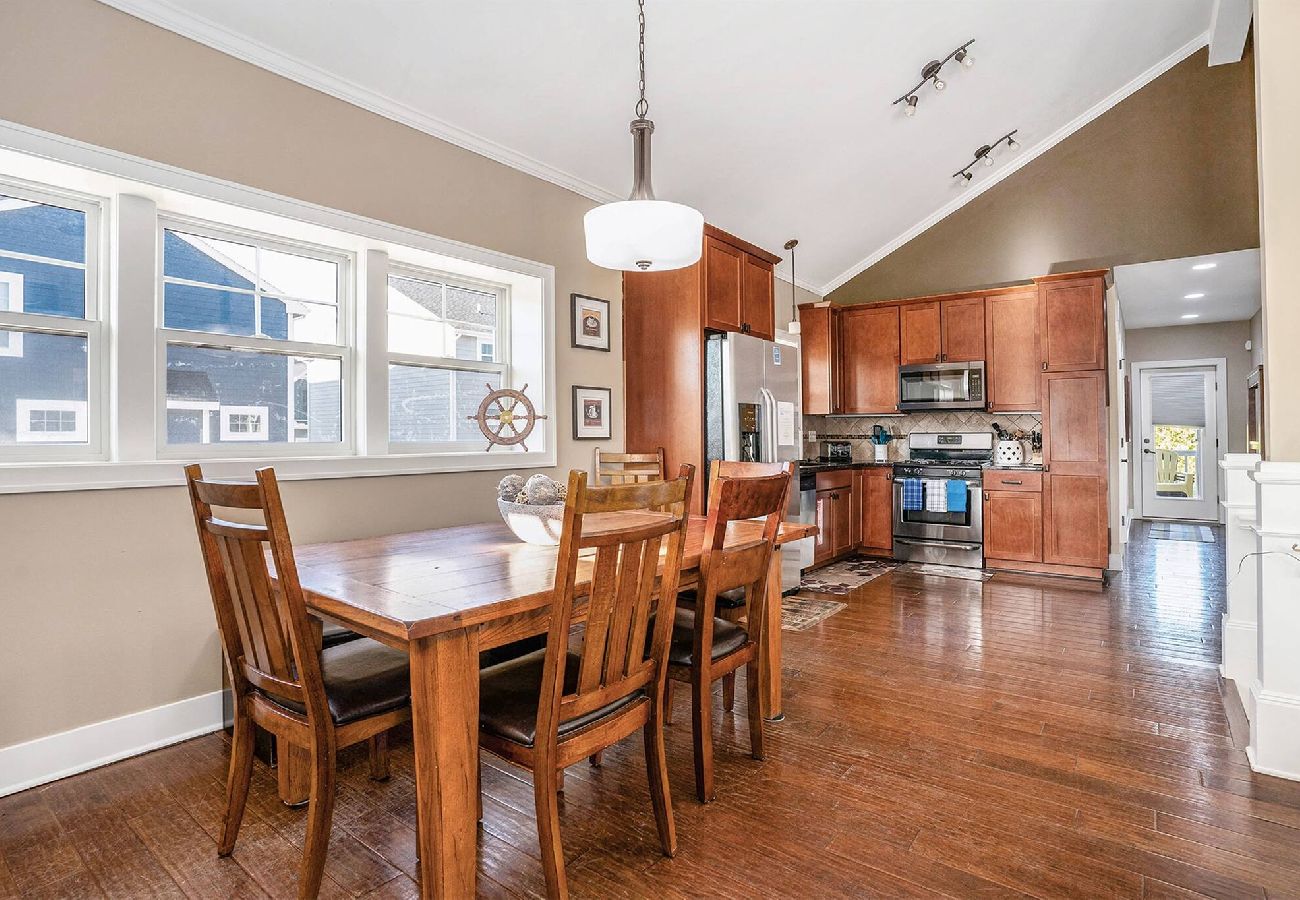Dining area with wooden table and chairs next to a full kitchen