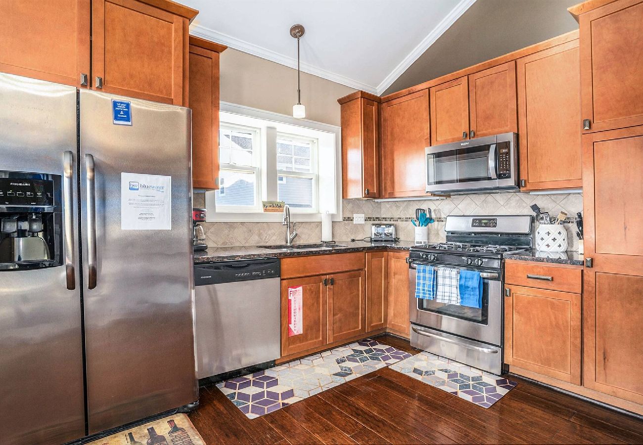 Kitchen with stainless steel refrigerator, stove, microwave, and wooden cabinetry