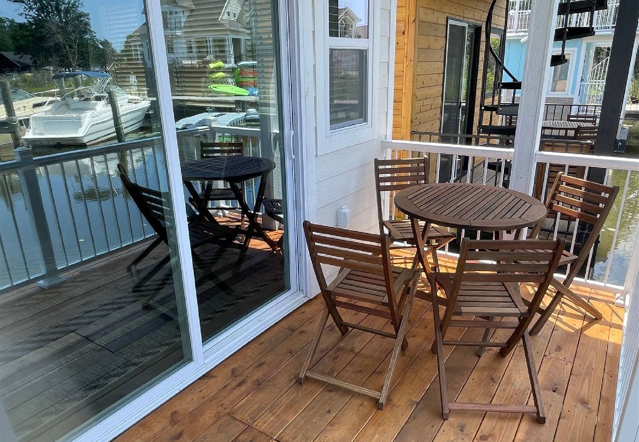 Small deck with bistro table and chairs overlooking the marina at Morning Glory Tiny Floating Cottage