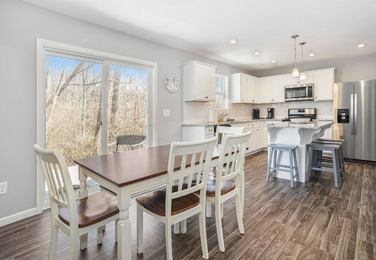Dining table by sliding glass doors overlooking woods