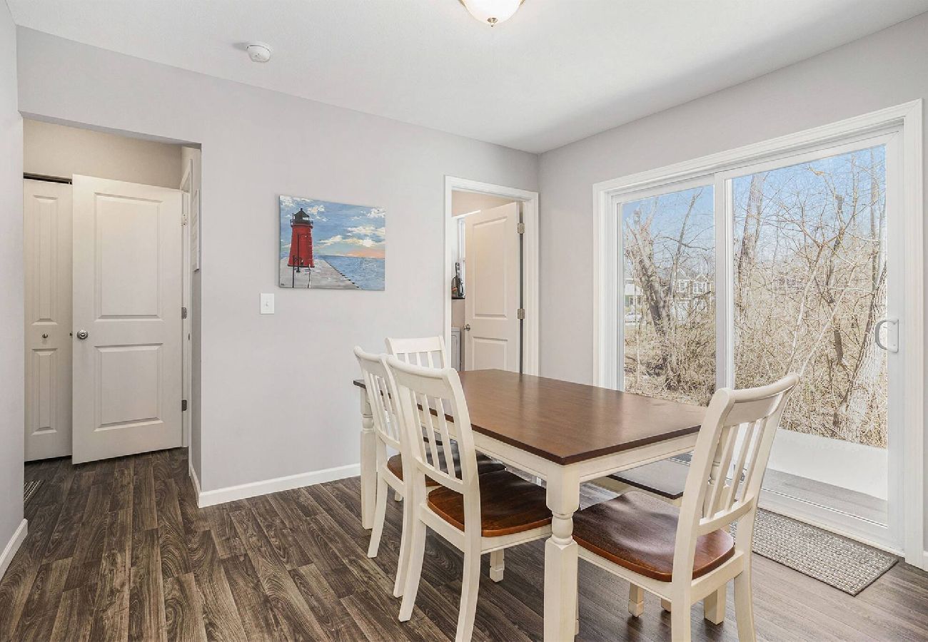 Dining table by large sliding doors with hall leading to half bath