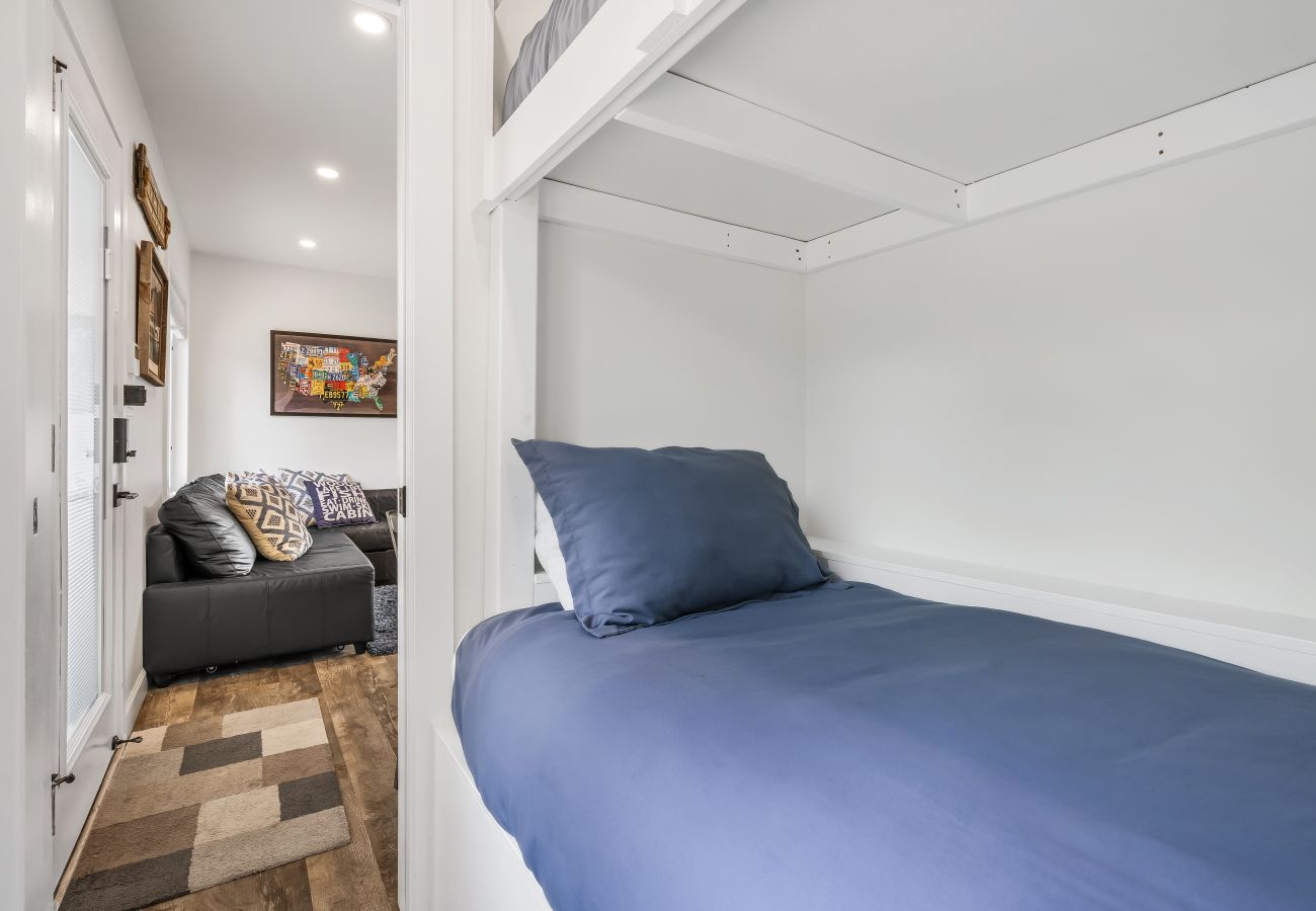 Twin bunk room with built- in bed and view into the living area at Aqua Vista Floating Cottage