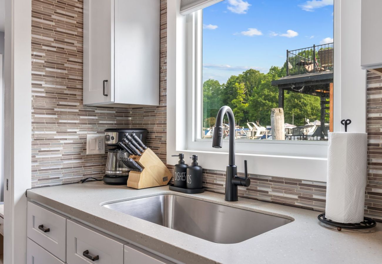 Modern kitchen sink, backsplace,knife set, and marina views