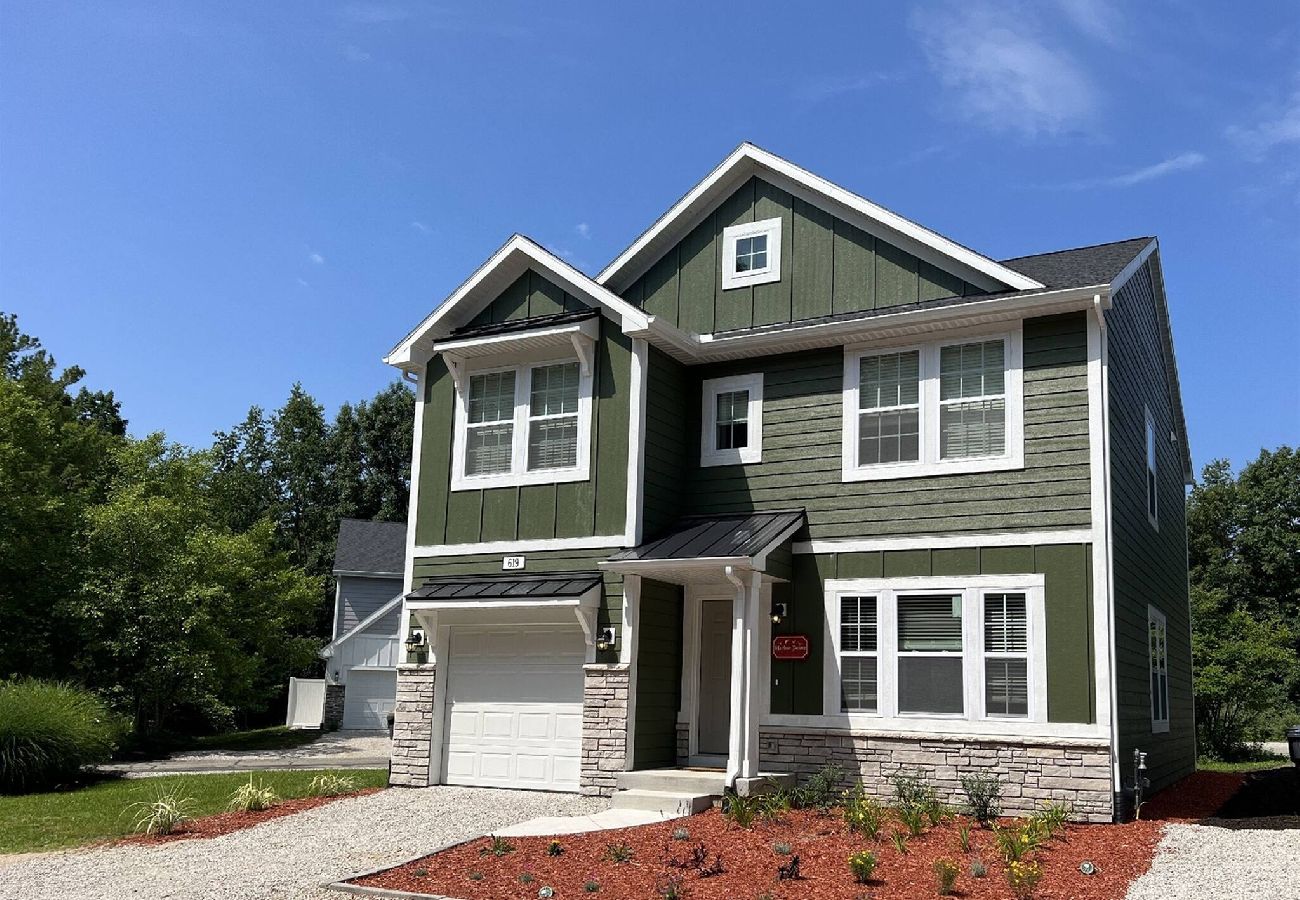 Exterior of Harbor Pointe vacation home with green siding, white trim, and covered front porch