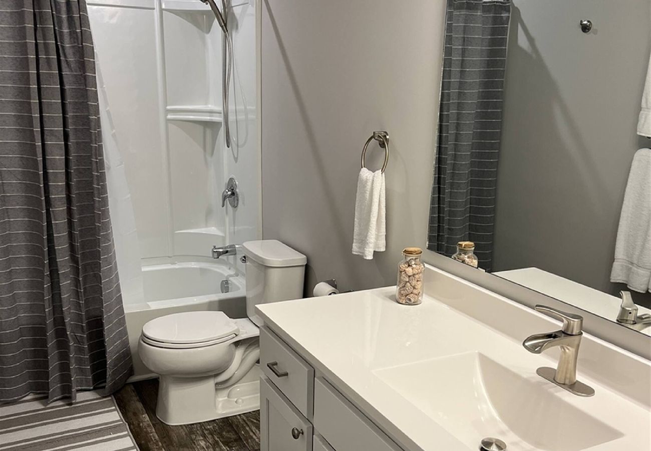 Harbor Pointe hall bathroom with large white vanity and shower/tub combo
