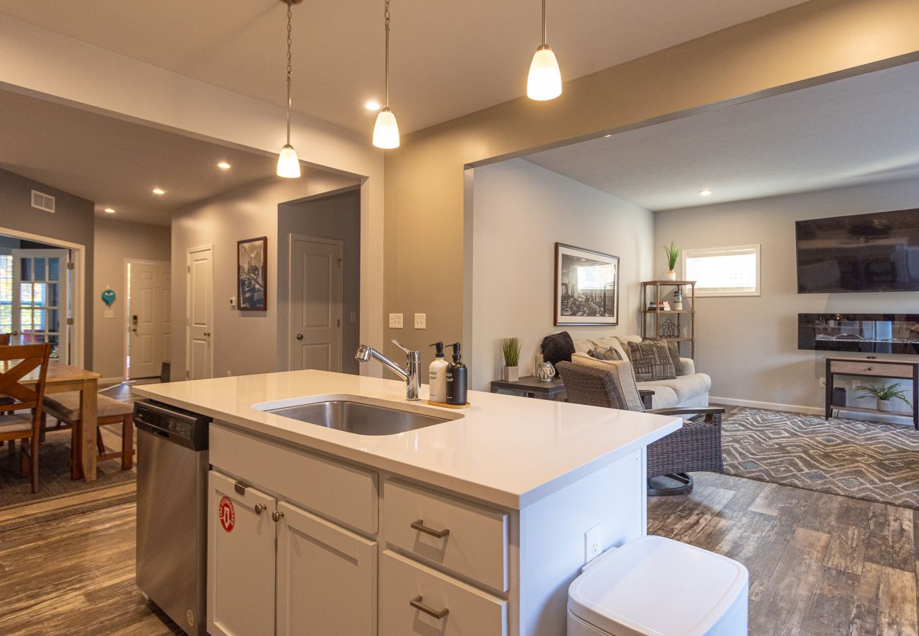 Open-concept main level at Harbor Pointe with kitchen island, stainless dishwasher, dining area, and living room