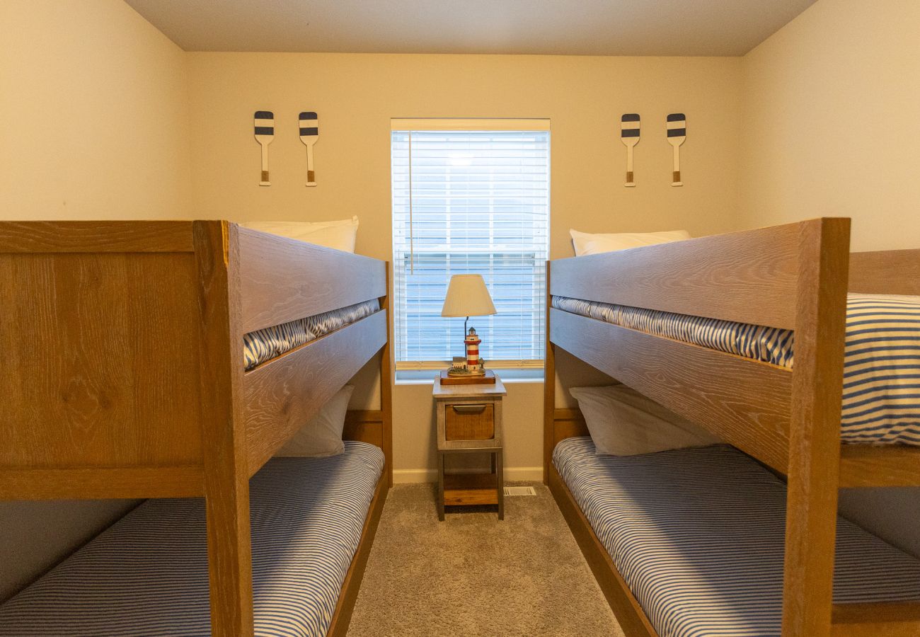Harbor Pointe bunk room with two wooden bunk beds, central nightstand, and lamp