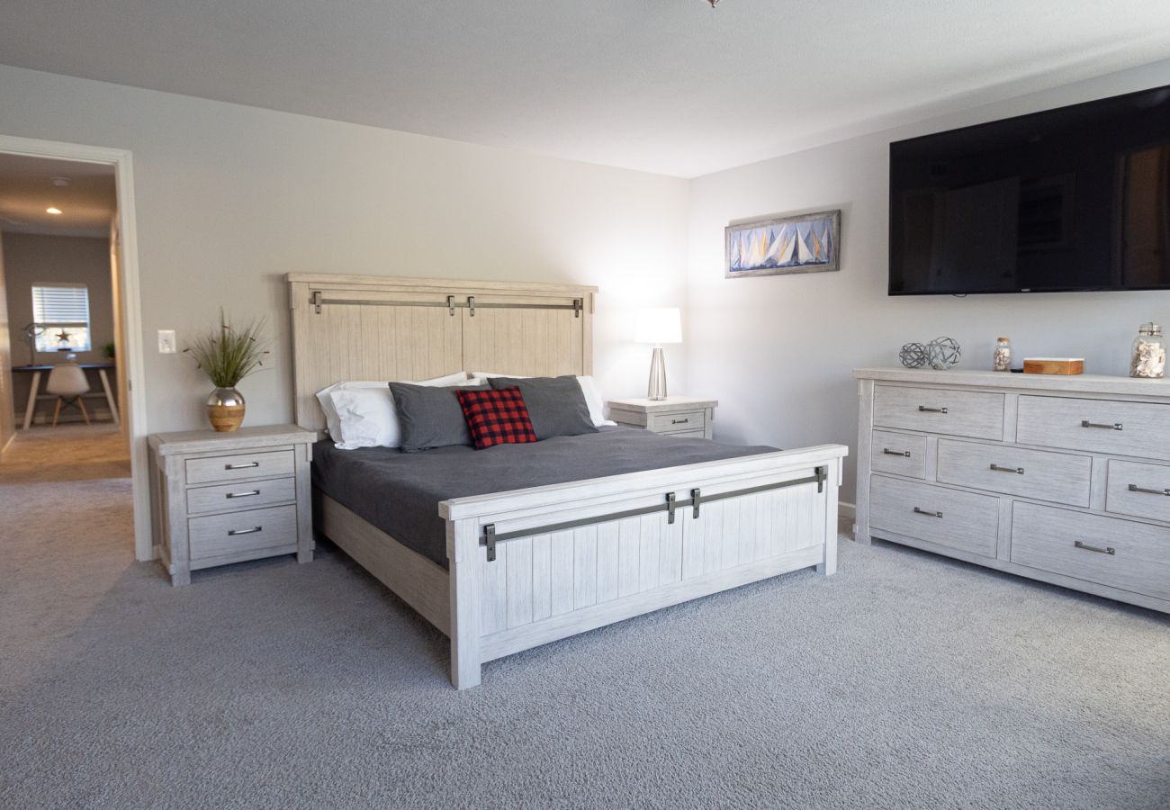 Primary bedroom at HArbor Pointe with king bed, matching nightstands and dresser.