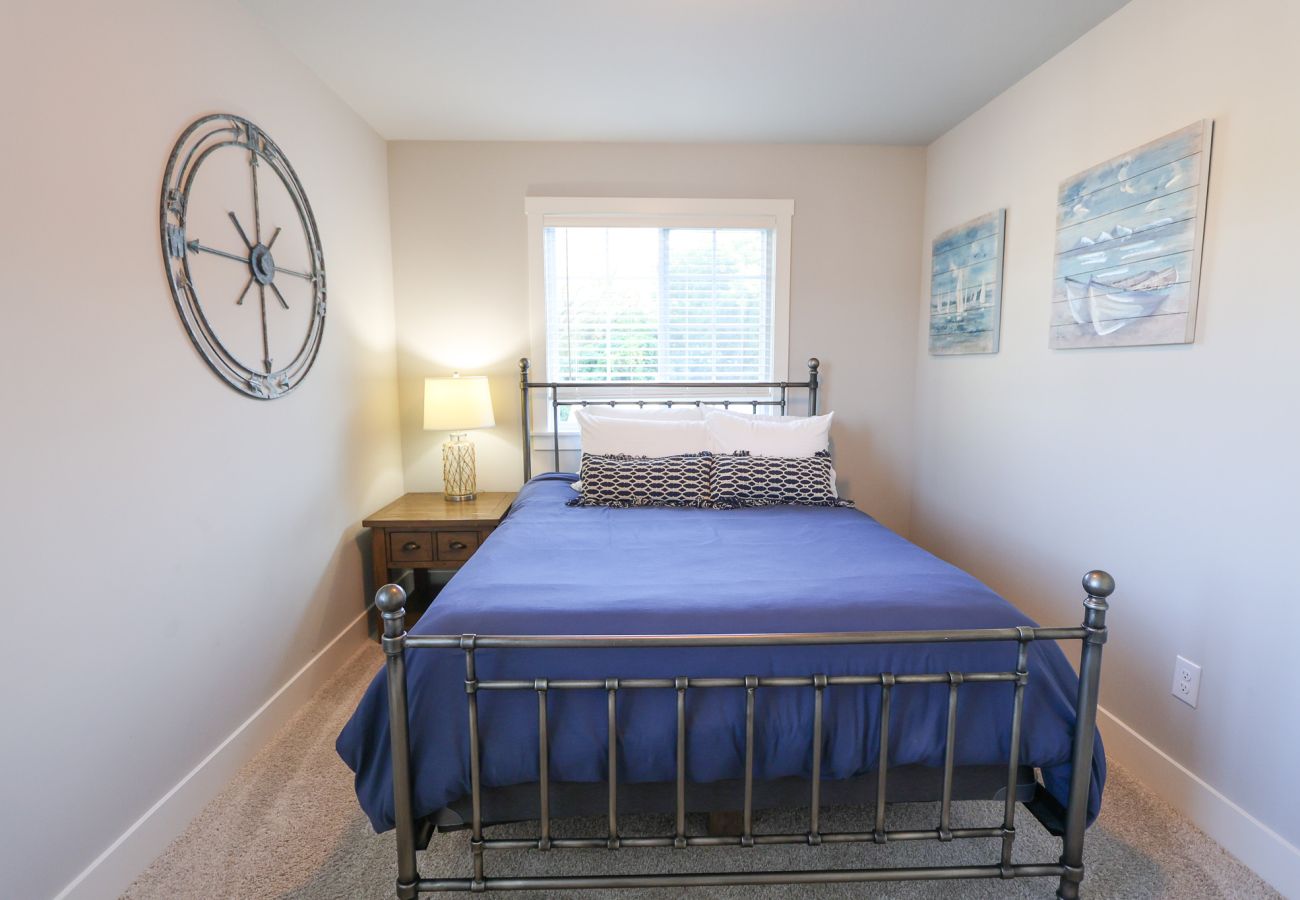 Bright bedroom with metal-frame bed and coastal decor at Blissful Daze