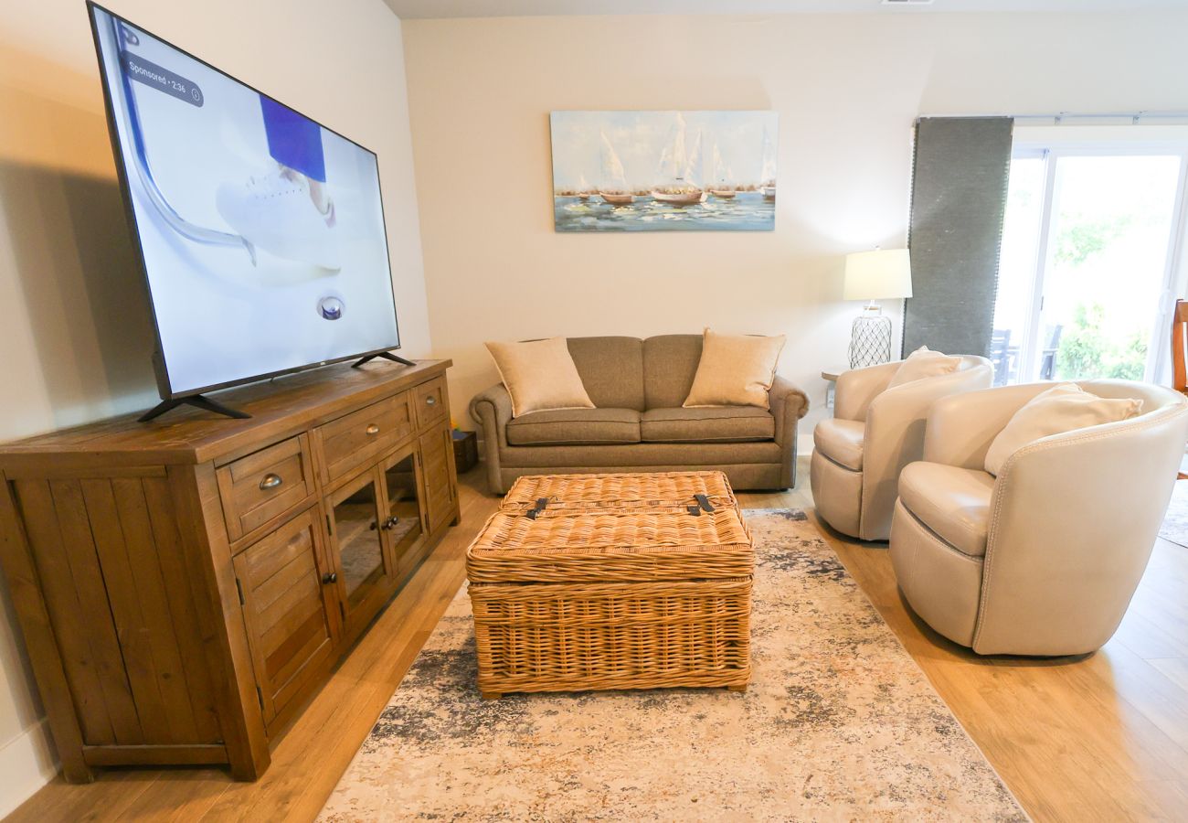 Living room with comfortable sofa,swivel chairs, and large smart TV
