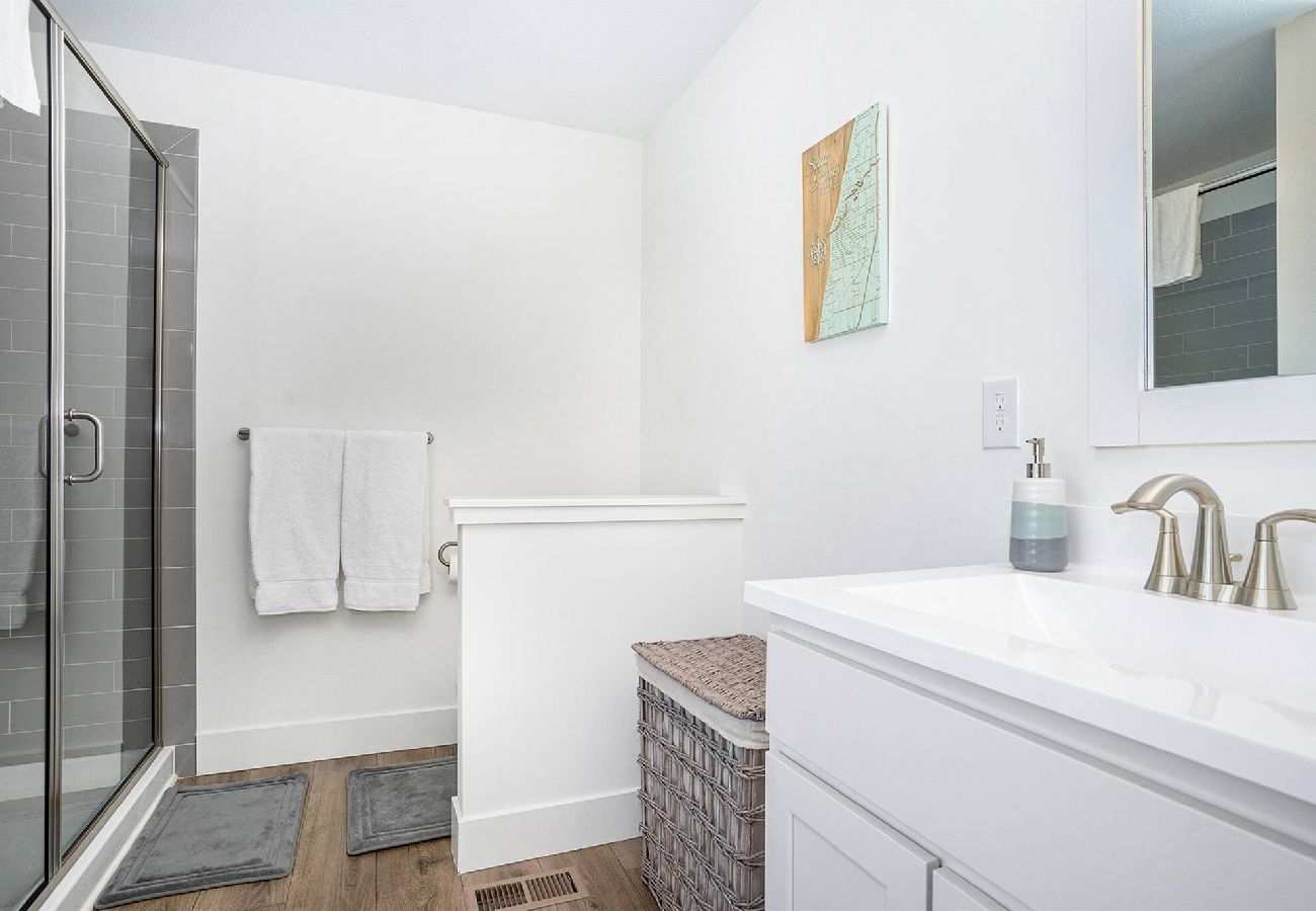 Primary bathroom with a glass walk-in shower and white vanity