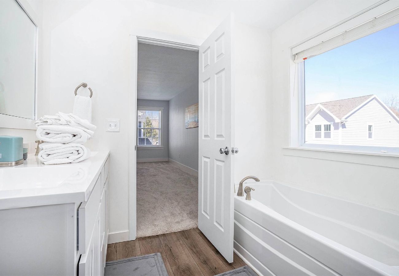 Primary bathroom with soaking tub and white vanity
