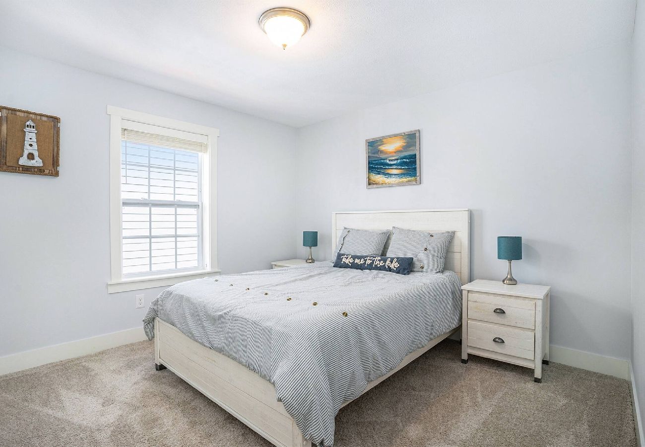 Bedroom with a queen bed, white furniture, and two nightstands