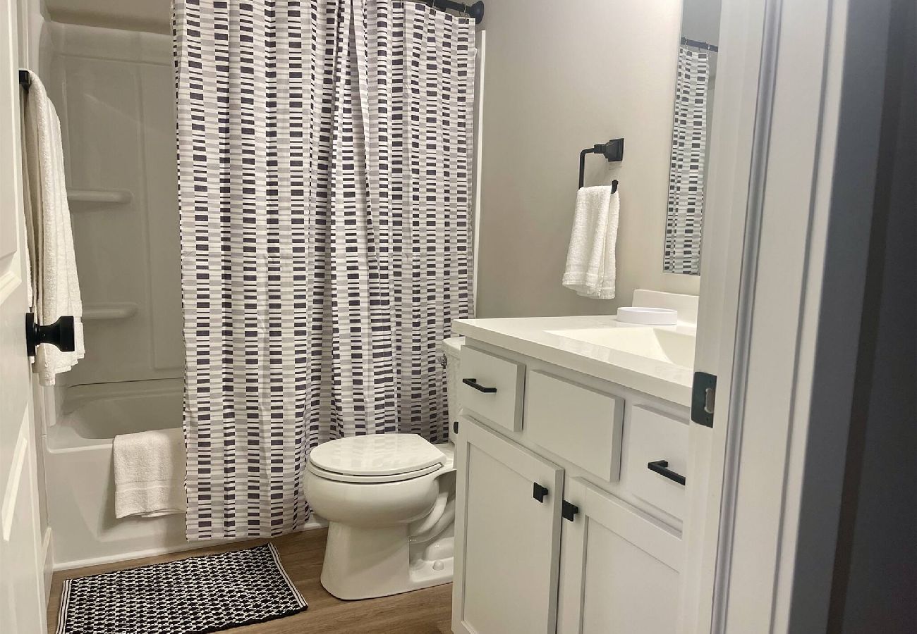 Modern bathroom with white vanity , and tub and shower combo