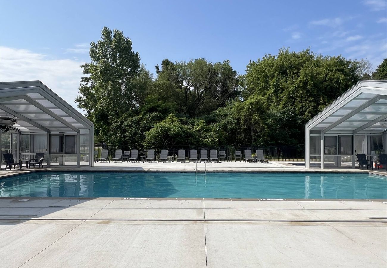 Large pool with retractable glass enclosure, and lounge chairs