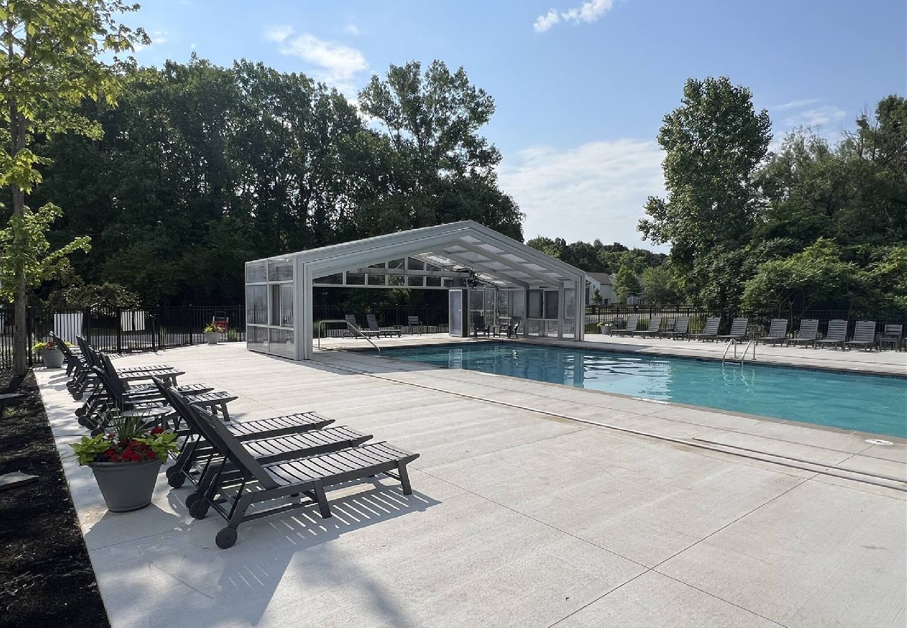 Pool with retractable glass enclosure and lounge chairs