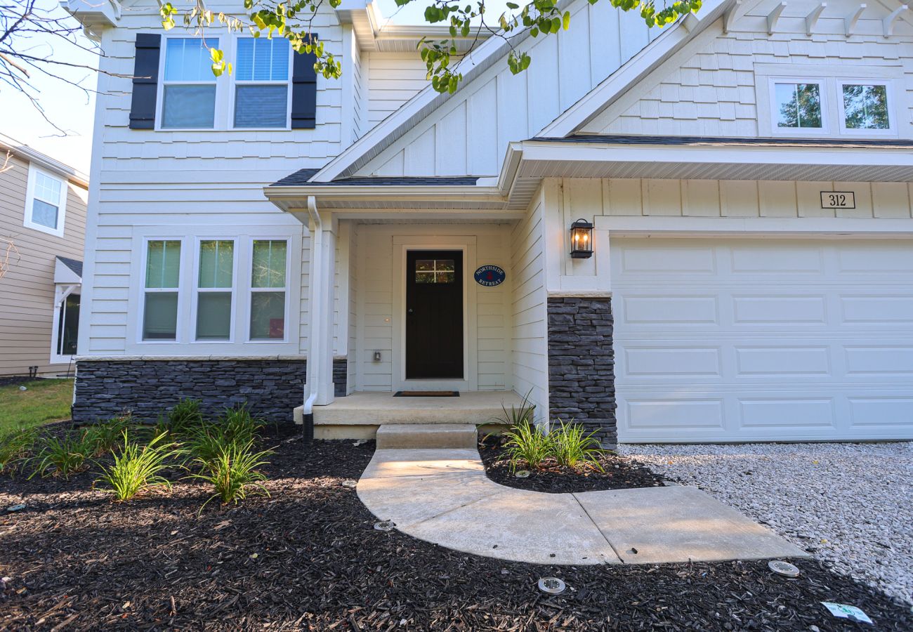 Front entry of Northside Retreat with stone accents and white exterior in South Haven, Michigan