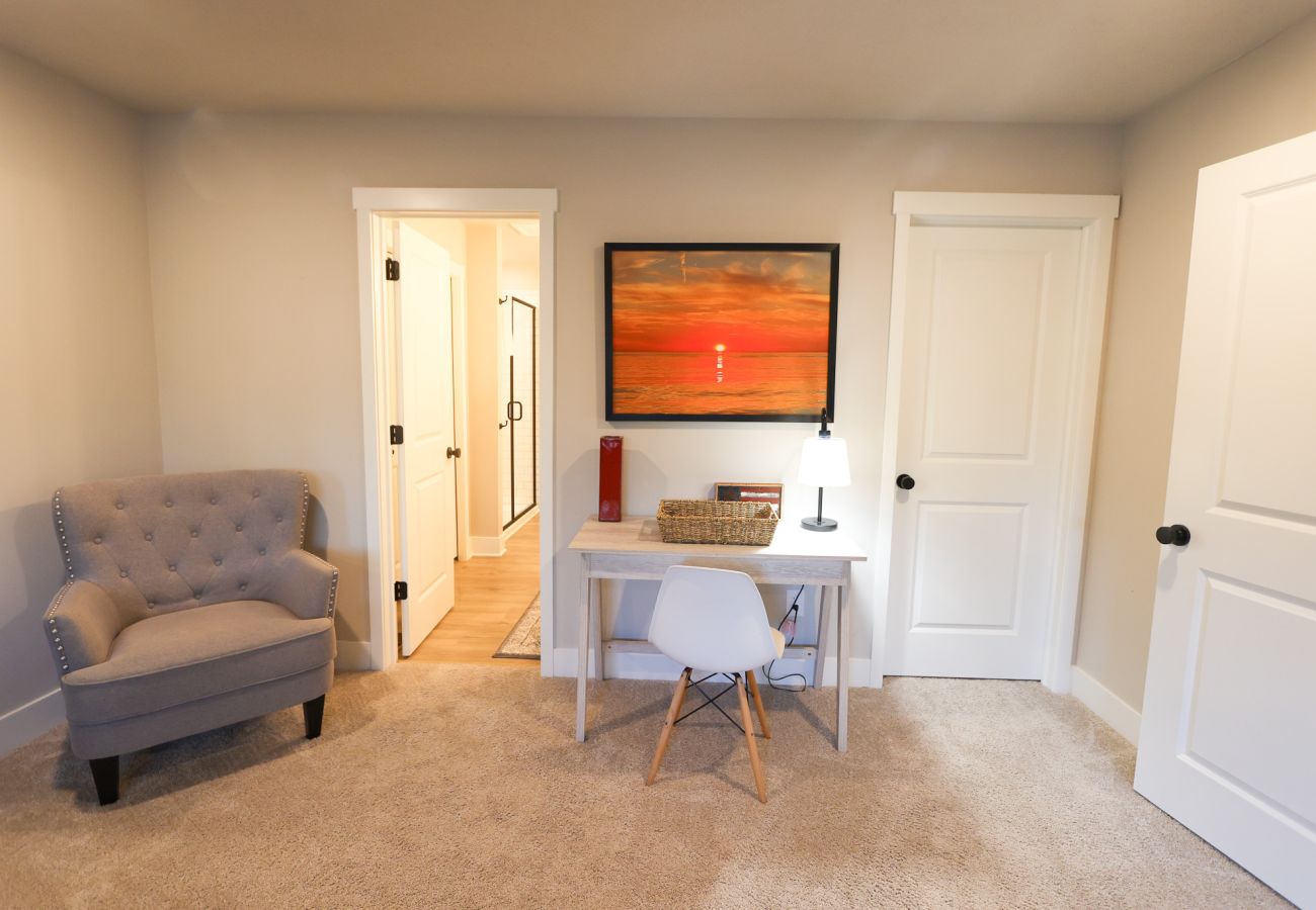 Bedroom sitting area with an armchair and light wood writing desk