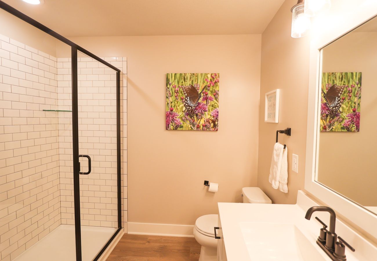 Modern primary bathroom at Northside Retreat with walk-in shower and black fixtures