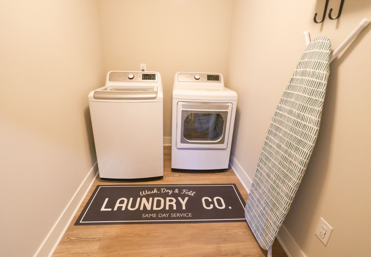 Laundry room with washer, dryer, ironing board, and iron 