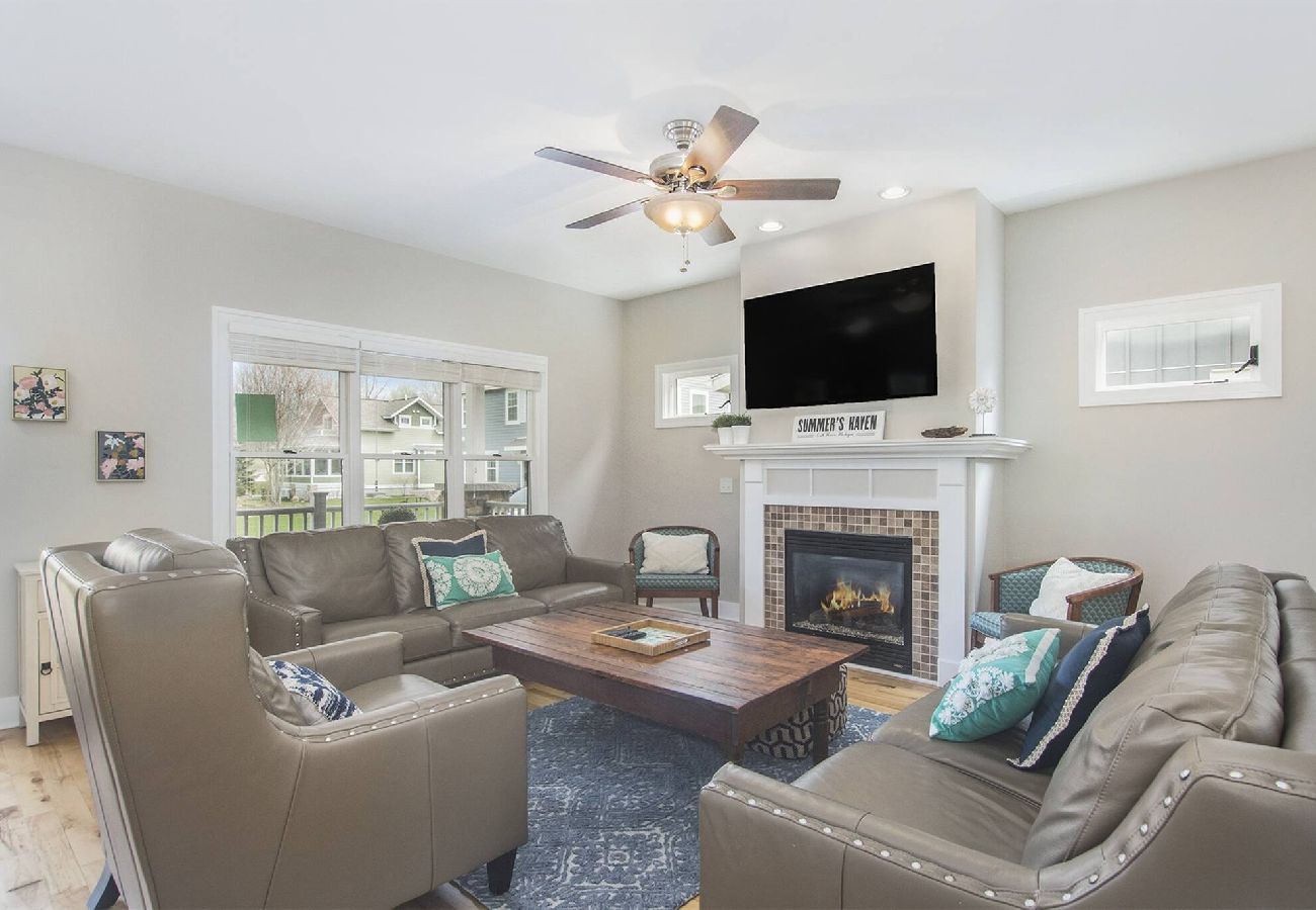 Cozy living room with leather seating, fireplace, and TV in South Haven