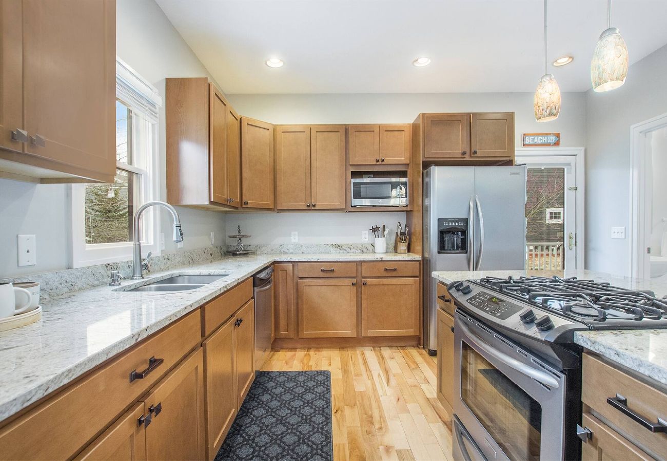 Bright kitchen with stainless appliances, wood cabinets, and spacious countertops 