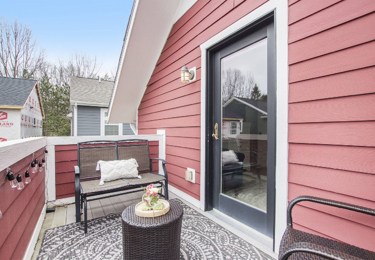 Cozy private balcony with seating and outdoor decor off the primary bedroom