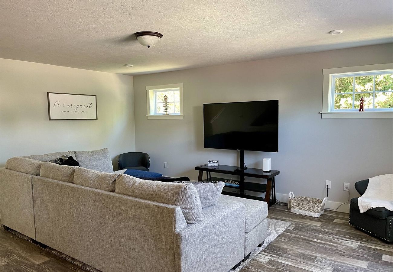 Spacious living room with gray sectional sofa, large TV and modern decor