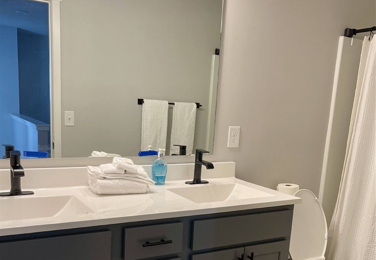Upstairs bathroom with double sink vanity, large mirror