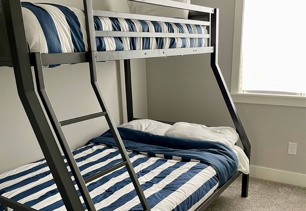 Basement bedroom with a twin-over-full metal bunk bed 