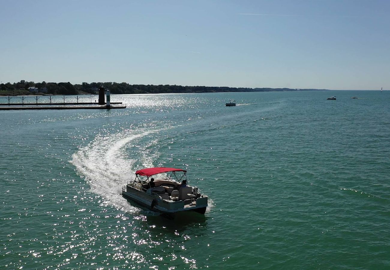 Blue water Boat Rentals boat cruising on Lake Michigan with sparkling water and distant shoreline 