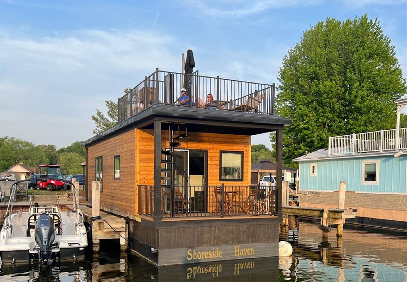 Floating tiny home with rooftop deck sitting directly on the water at Woodland Harbor marina