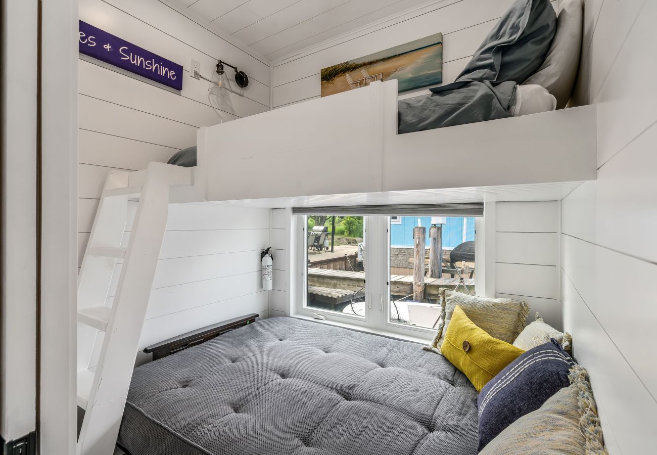 Bunk-style bedroom at Shoreside Haven with lower lounge bed and upper loft bed