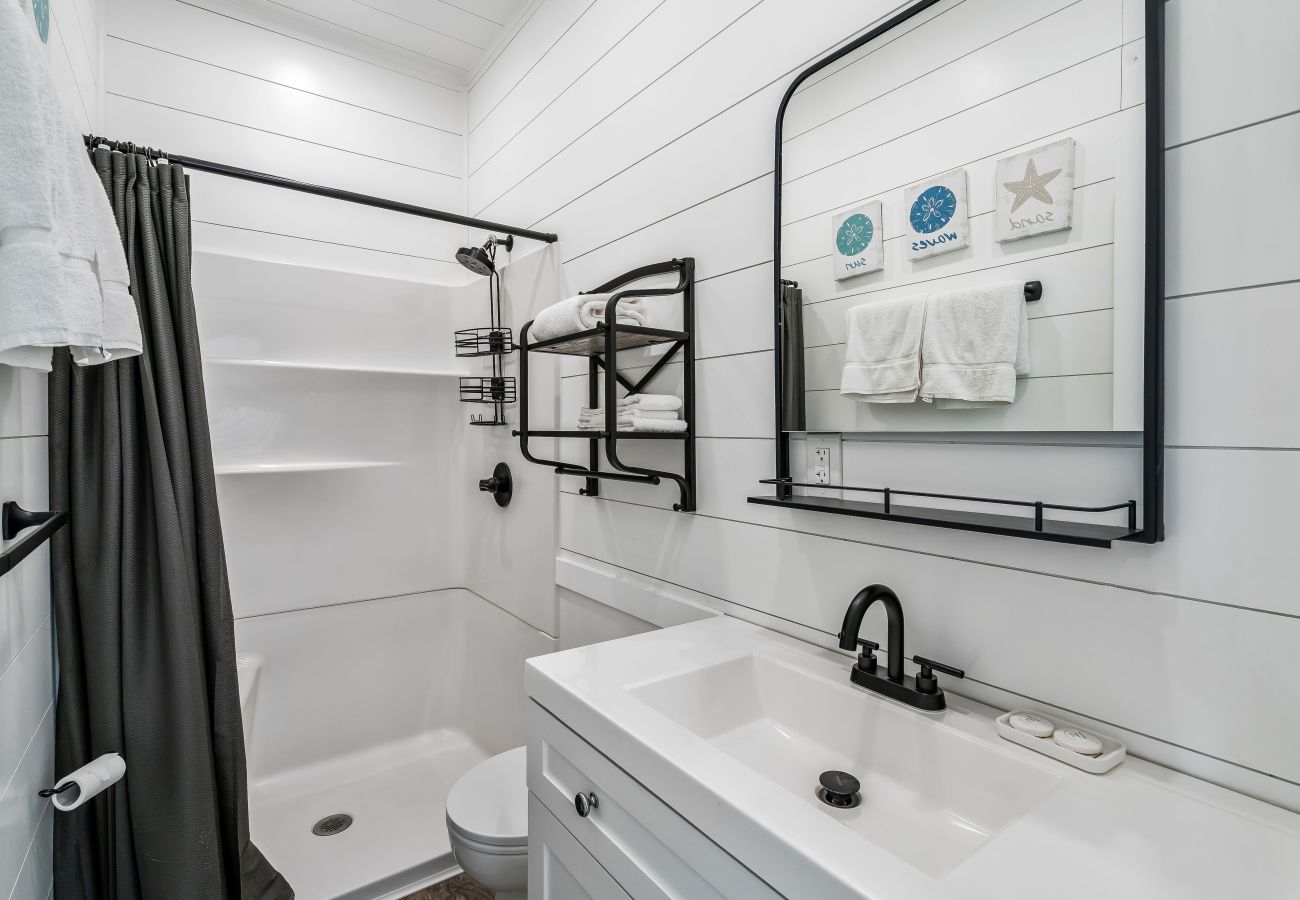 Rv style toilet,walk-in shower, white cabinetry 