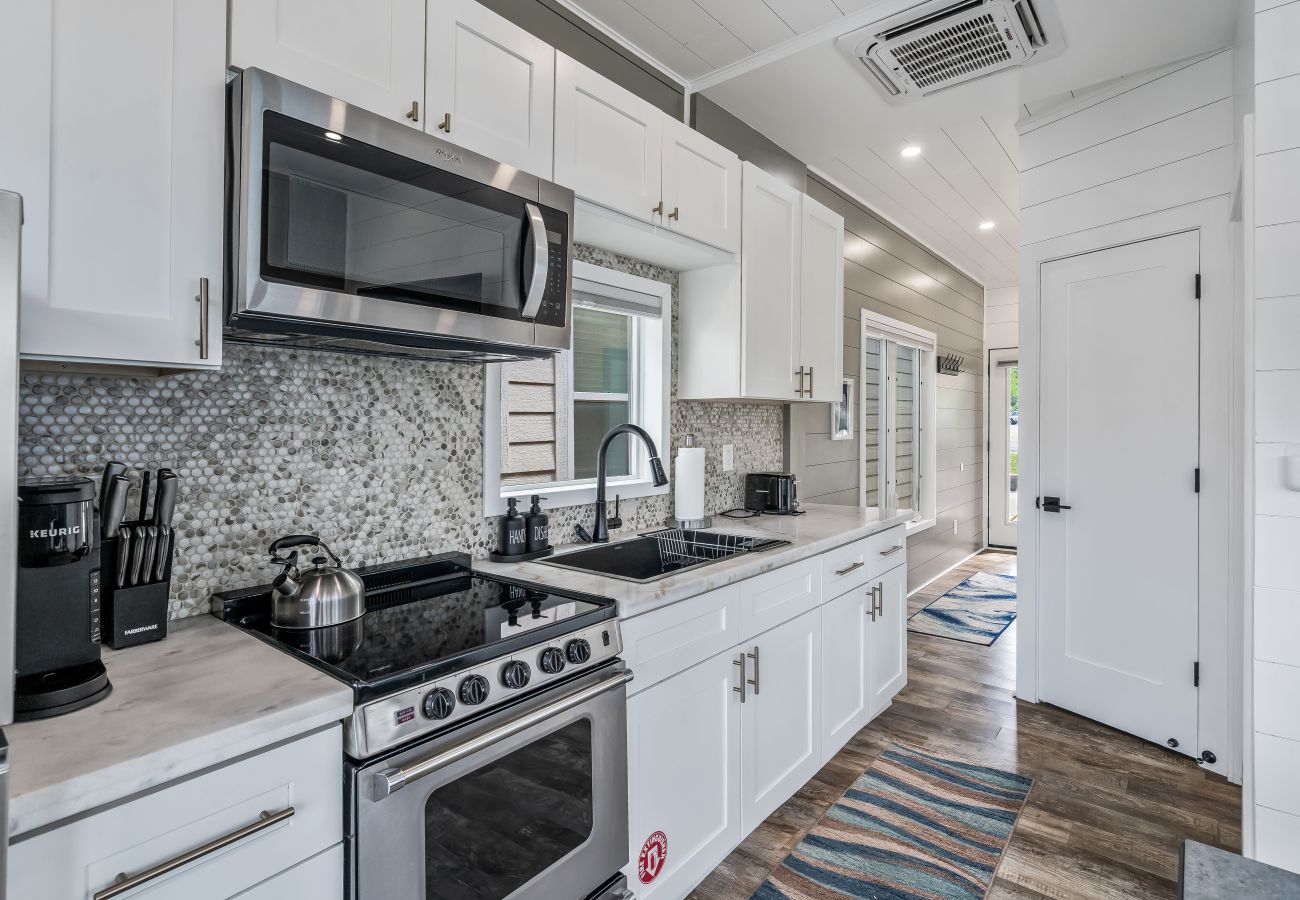 Kitchen at Shoreside Haven with stainless appliances, white cabinetry, and deep sink