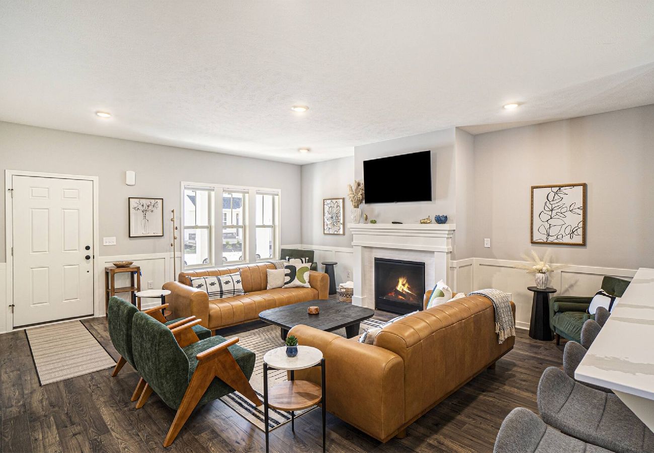 Bright living room with leather sofas and fireplace