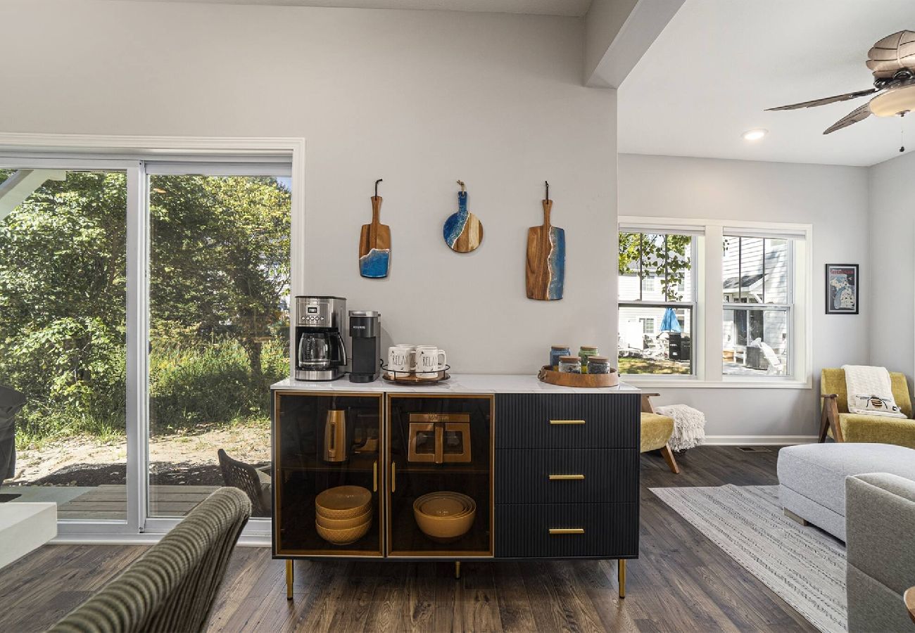 Modern coffee bar with drip coffee maker, Keurig, and cabinet near sliding doors