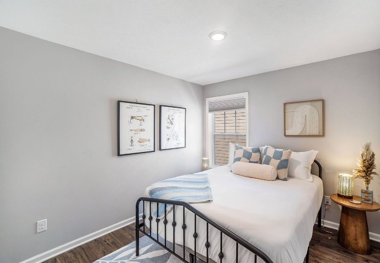 bedroom with queen size bed, modern artwork, and soft neutral decor 