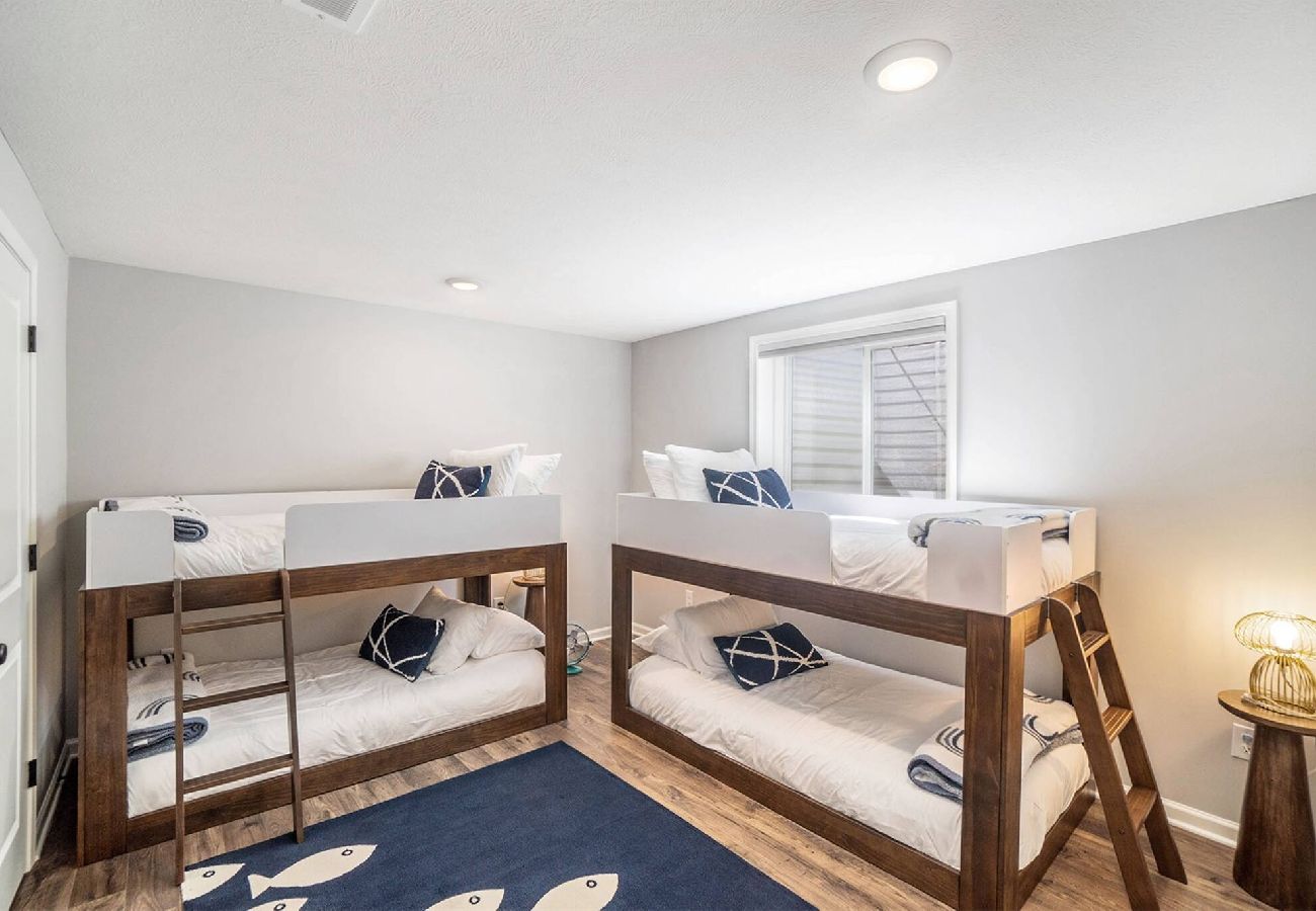Basment bedroom with two twin-over-twin bunk beds and nautical decor