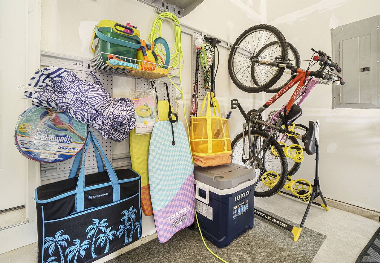 Garage stocked with bikes, beach chairs, boogie boards, cooler, and pool toys