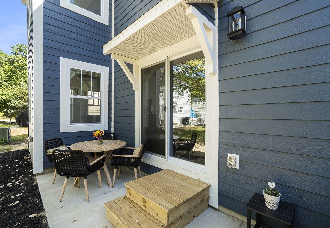 Small private patio with round table, chairs, and sliding door