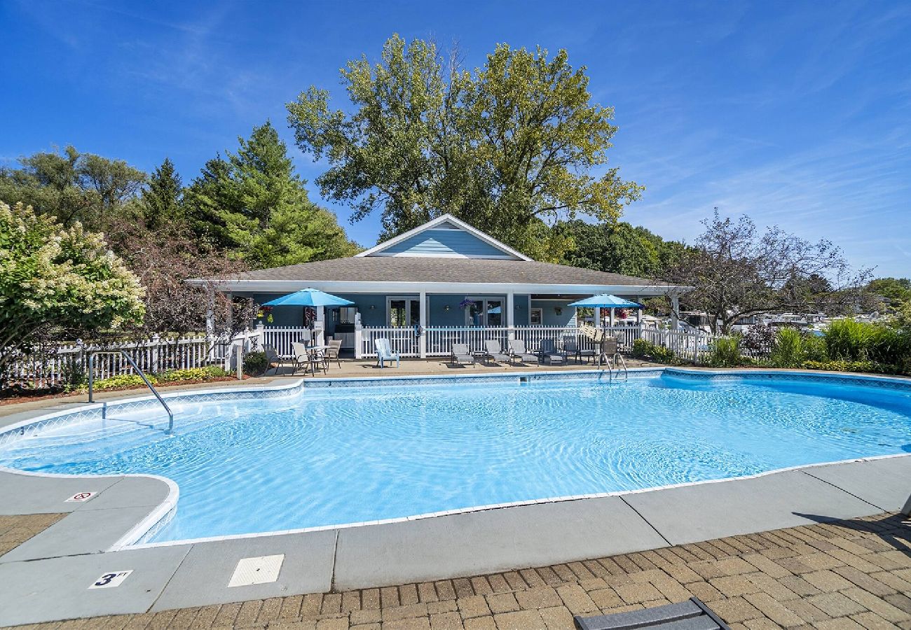 Outdoor swimming pool with lounge chairs and clubhouse at Woodland Harbor Marina