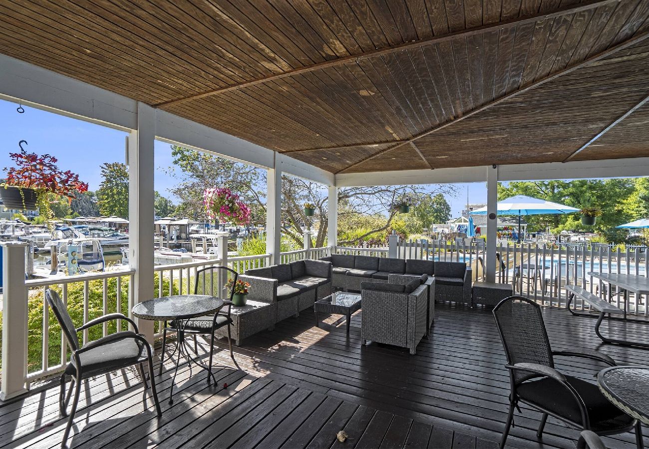Shaded outdoor patio with lounge seating and marina views at Woodland Harbor Marina clubhouse