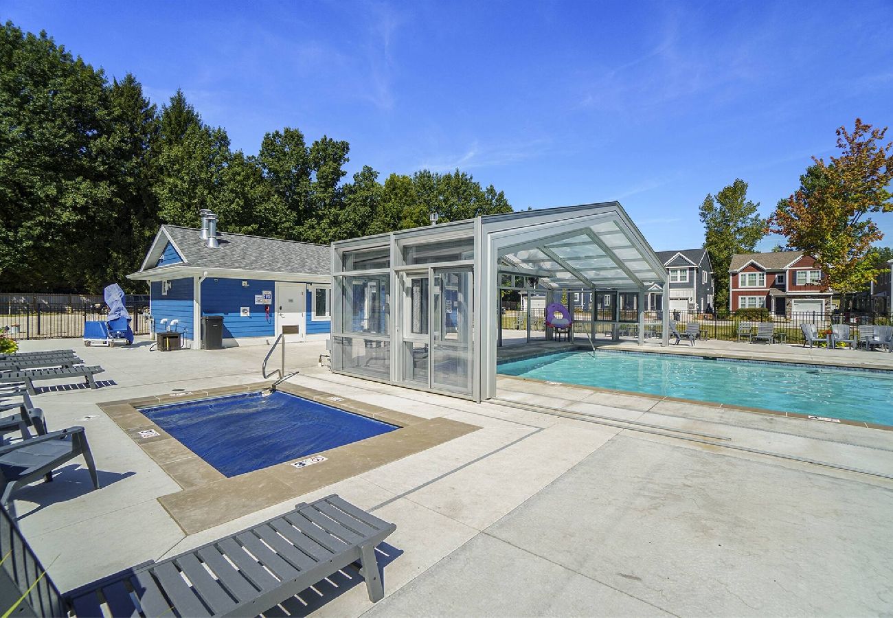 Outdoor hot tub and indoor/outdoor pool area with loungers at Harbor Club.